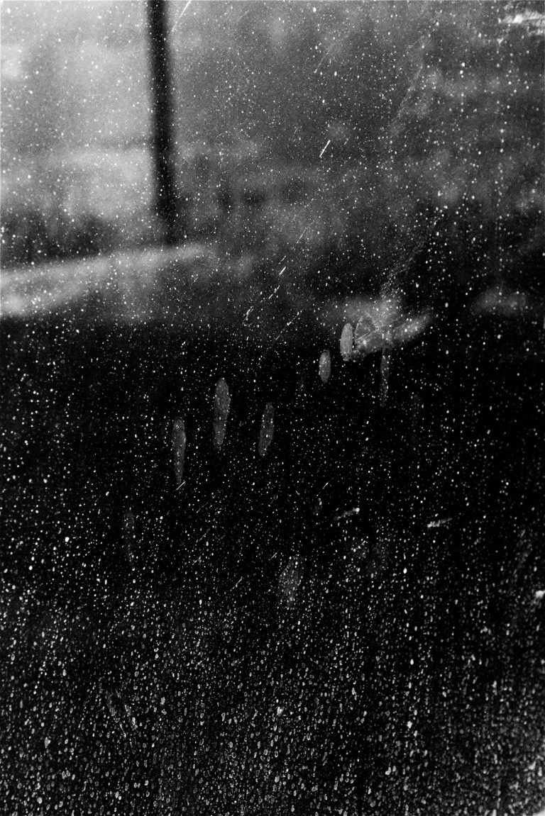 Artistic Black and white picture with the perspective of someone looking out of the window during a rainy day